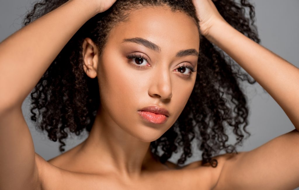 Woman holding back her hair to show off her beautiful eyebrows
