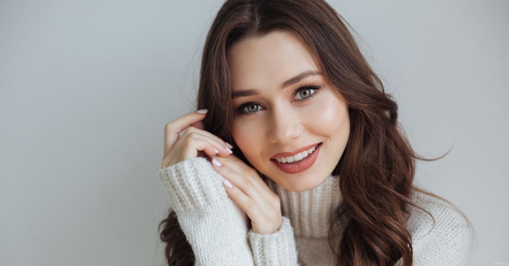 Woman smiling post recovery from facial plastic surgery in the winter (model)
