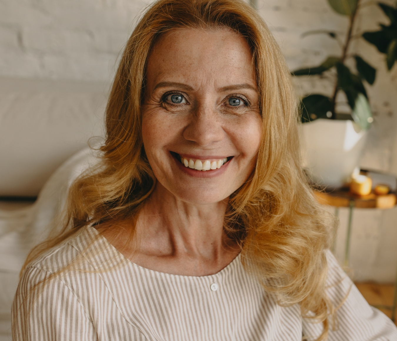 Woman sitting down to dinner smiling
