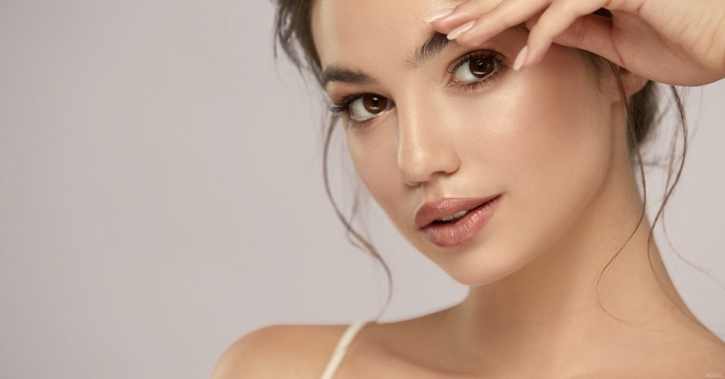 Woman facing camera with straight, defined nose, used to illustrate revision rhinoplasty (model)